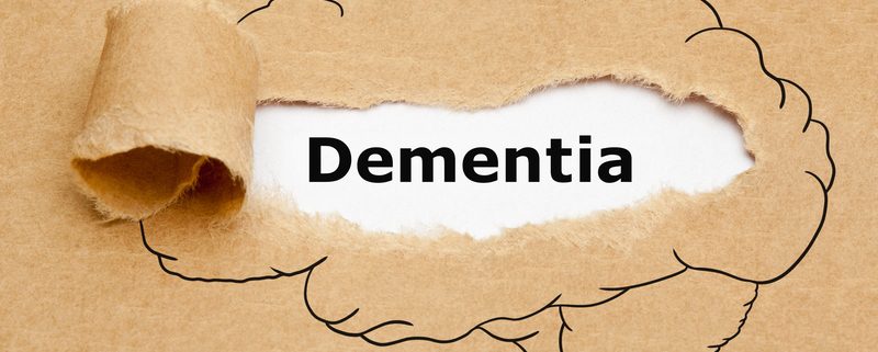 A torn piece of paper with the word dementia written underneath it.