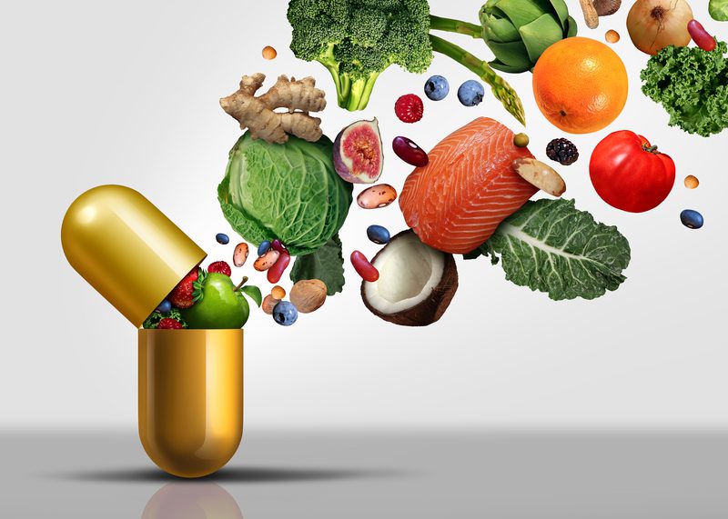 A pill with fruits and vegetables flying out of it.