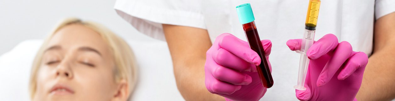 A person holding a tube of blood in their hands.