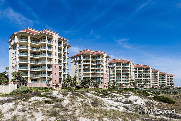 A group of buildings on the beach near sand dunes.
