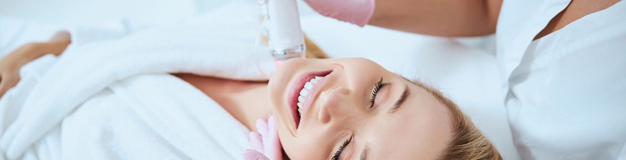 A woman getting her teeth cleaned by an esthetician.